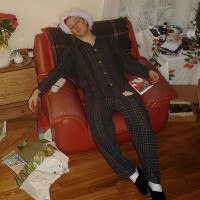 Man in pajamas and Santa hat in an armchair
