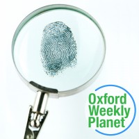 Magnifying glass focused on a fingerprint with the Oxford Weekly Planet logo in the foreground