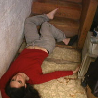 Woman lying at the bottom of a staircase