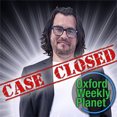 Smirking man with dark hair and glasses with the words "Case Closed" and the Oxford Weekly Planet logo in the foreground