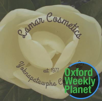 Lamar Cosmetics magnolia blossom logo with the Oxford Weekly Planet logo in the foreground