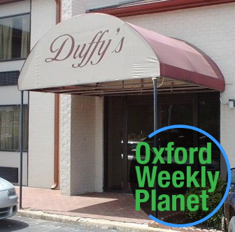 Photo of the Duffy's Bar & Grill entrance with the Oxford Weekly Planet logo in the foreground