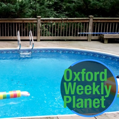 Swimming pool with the Oxford Weekly Planet logo in the foreground
