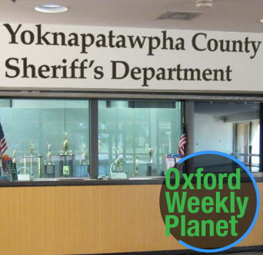 Front desk of the Yoknapatawpha County Sheriff's Department with the Oxford Weekly Planet logo in the foreground