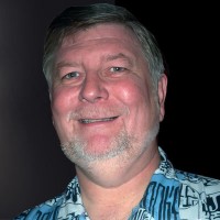 Smiling man with gray hair and facial hair