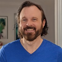 Smiling man with dark hair and facial hair