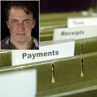 Hanging files with finance-related labels with an inset of a serious man with short dark hair in the foreground