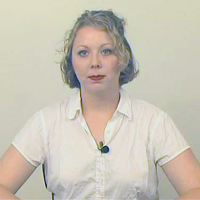 Woman with short blonde hair wearing a white shirt