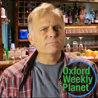 Blond man in a bar with the Oxford Weekly Planet logo in the foreground