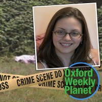 Crime scene tape in front of a covered body in a grassy location with a bespectacled brunette woman and the Oxford Weekly Planet logo in the foreground