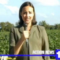 Woman holding a microphone with a cotton field in the background and a news chyron in the foreground