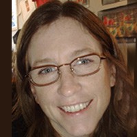 Smiling woman with long dark hair and glasses