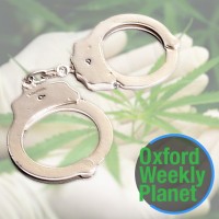 Gloved hands holding a marijuana plant with handcuffs and the Oxford Weekly Planet logo in the foreground