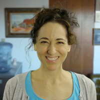 Smiling woman with curly dark hair in an updo