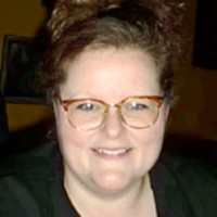 Smiling woman with brown hair and glasses