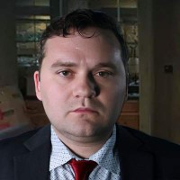 Dark-haired man in a coat and tie