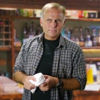 Blond man holding a bar towel