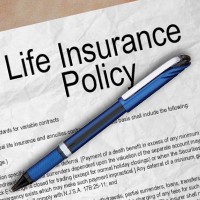 Photo of a portion of a life insurance document with a blue pen laid across it