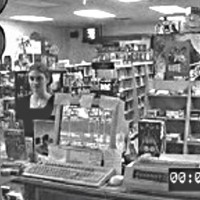 Still image from store security video showing a young woman at the register