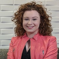 Smiling young woman with wavy brown hair