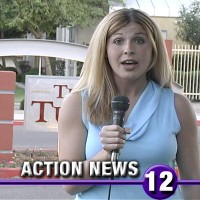 Blonde female reporter in front of an apartment complex entrance