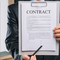 Person holding a clipboard with a contract on it