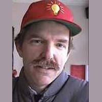 Man with brown hair and mustache wearing a red baseball cap