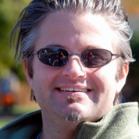 Smiling man with salt-and-pepper hair and facial hair