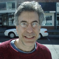 Smiling man with glasses and graying hair