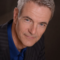 Smiling older man with short gray hair and blue eyes