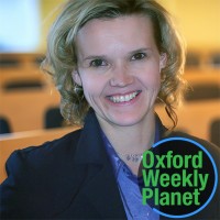 Smiling blonde woman with the Oxford Weekly Planet logo in the foreground