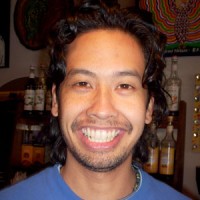 Smiling man with medium-length curly black hair