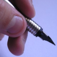 Man's hand holding a fountain pen