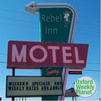 Rebel Inn motel sign with the Oxford Weekly Planet logo in the foreground
