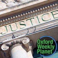 Courthouse with "justice" inscribed and the Oxford Weekly Planet logo in the foreground