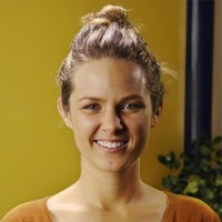 Smiling young woman with light brown hair in a topknot