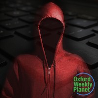 Faceless person in a red hoodie with the Oxford Weekly Planet logo in the foreground