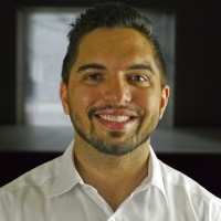 Smiling man with short dark hair and facial hair