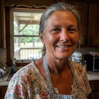 Smiling older woman with gray hair in a low ponytail