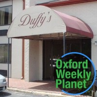 Photo of the Duffy's Bar & Grill entrance with the Oxford Weekly Planet logo in the foreground