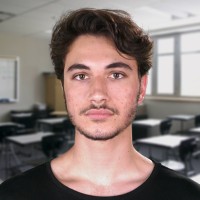 Young man with short wavy dark hair and dark mustache and beard