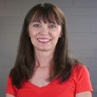 Smiling woman with long dark hair and bangs