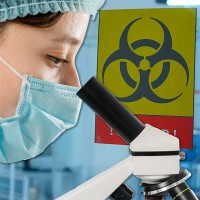 Person wearing a medical cap and mask, looking into a microscope