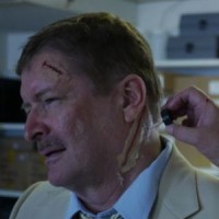 latex slash wound prosthetic being applied to actor's neck