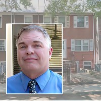 Brick apartment building with an inset photo of a man with a round face and gray hair, white at the temples