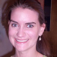 Broadly smiling woman with long brown hair