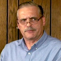 Older man with glasses, thinning gray hair and a mustache