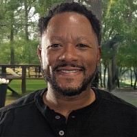 Smiling man with short dark hair and facial hair