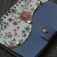 Wire-bound notebook with floral decoration and snap close