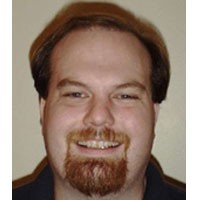 Smiling man with reddish brown hair and goatee